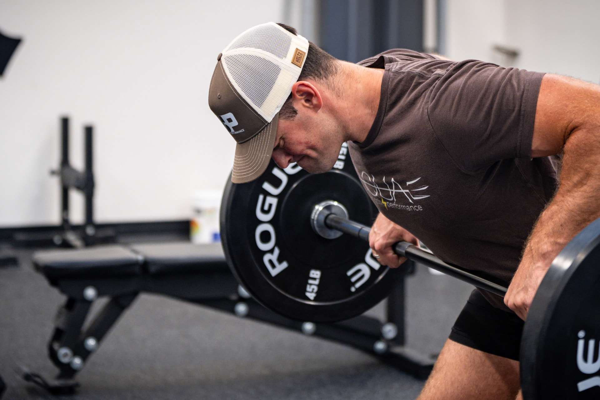 Athlete loading a heavy barbell row in the gym